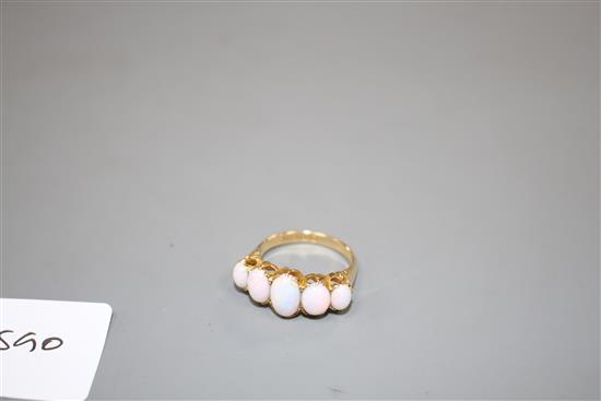 An Edwardian 18ct gold and graduated five stone white opal half hoop ring, size Q, gross 5.5 grams.